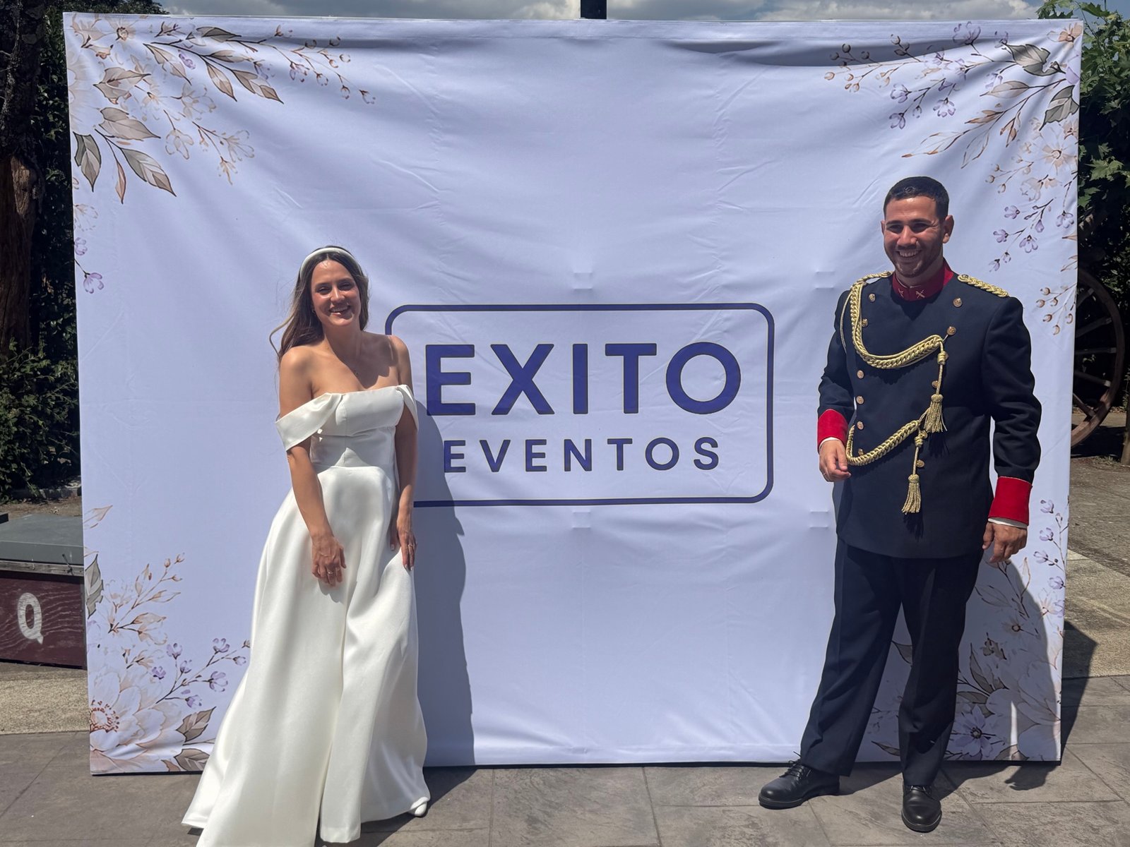 Novios posando frente al fotocall de Éxito Eventos en su boda